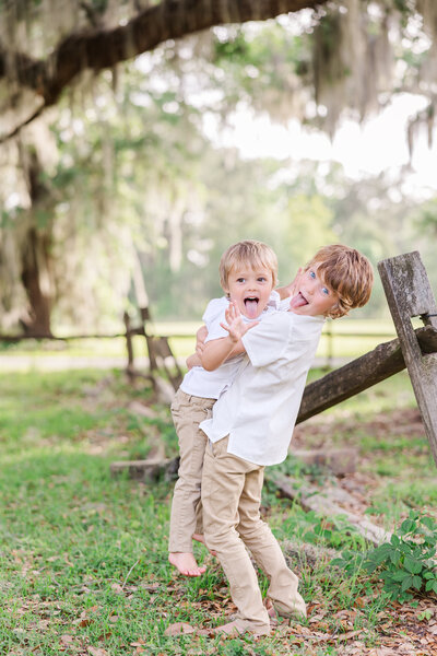 boy holding his younger brother and making faces