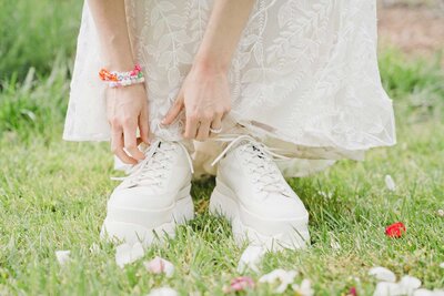 Bride tying platform white wedding sneakers