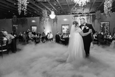 Bride and groom share a first dance as smoke fills the dance floor