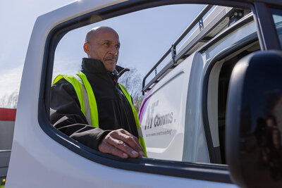 A man in a high visibility vest getting into a white van. Taken on location at Petans, Norwich by Claire Howes. 