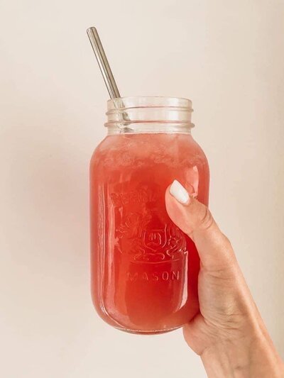 Hand holding jar of happy juice wih straw