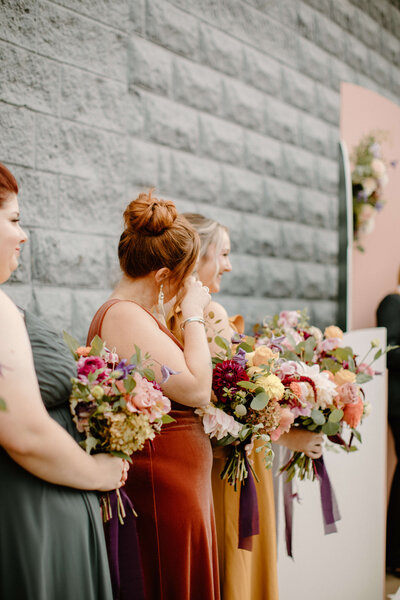 Colorful fall bridesmaids watching a ceremony