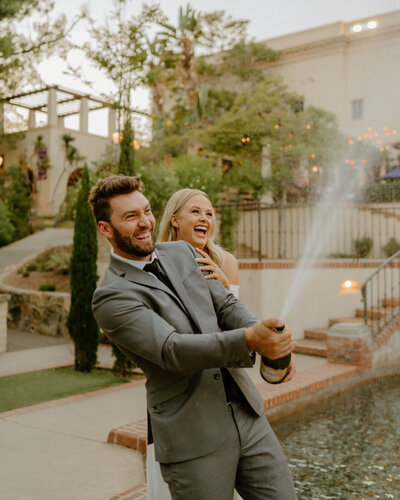 bride and groom popping champagne