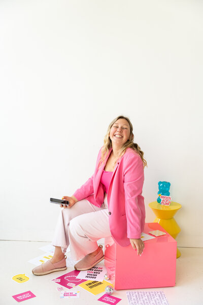 Hand with pink sleeve holding up an iphone with an Instagram account page on the screen