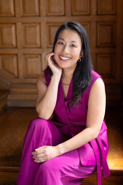 Professional headshot of woman in purple dress
