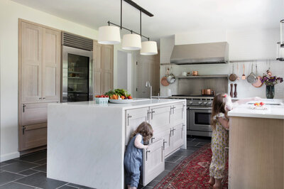 Kitchen renovation for a young family adds windows for backyard access, utilizing adjacent dining room space for appliances and storage. Modern aesthetic with farmhouse feels.