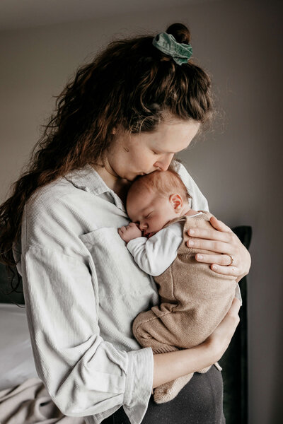 Baby ligt te slapen in de armen van papa