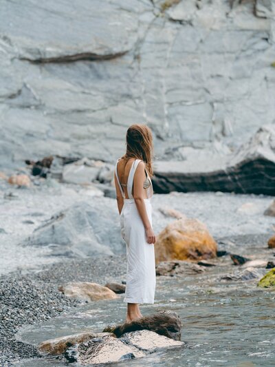 woman standing in water on shore