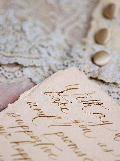 Handwritten calligraphy with chestnut ink and the slightest detail of an heirloom bralette for a luxury boudoir session