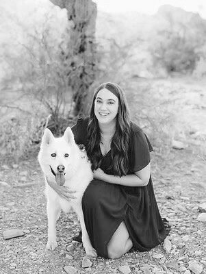 Woman hugging white husky dog and smiling