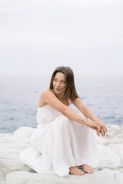 Bride sitting on a rock on Crete in Greece
