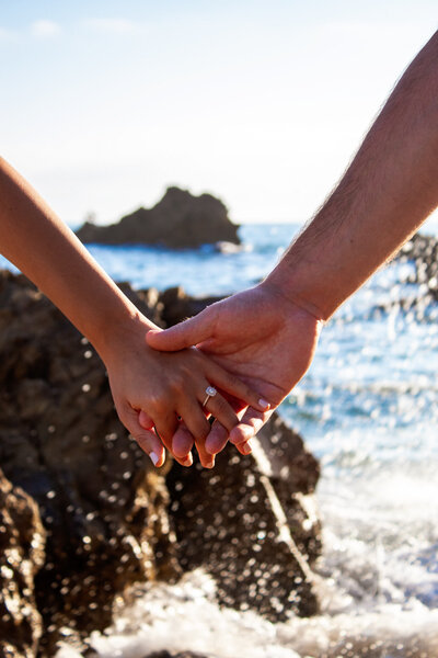 couple holding hands on san diego beach