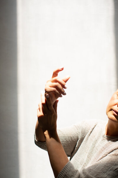 Middle aged woman holding her arm gently in the air