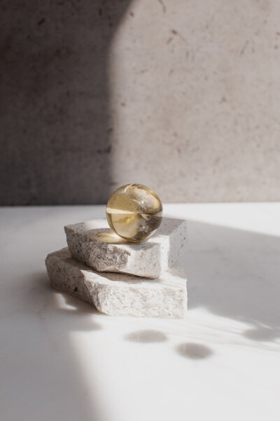 A high quality orange citrine crystal sphere - our mRNA ball, on a quartz slab.