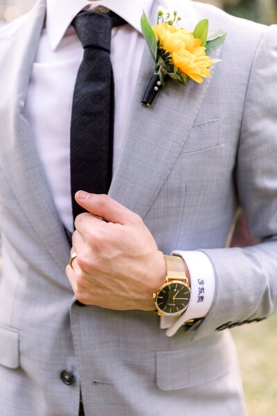 Close up of groom's torso with a sunflower