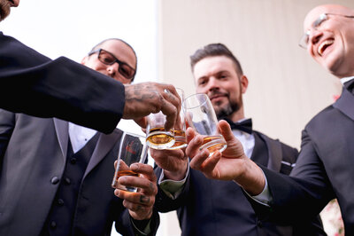 Groomsmen clicking thei drinks.