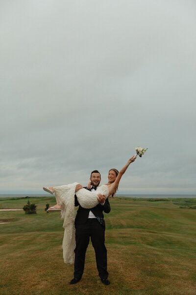 groom holding bride at wedding in prince edward island