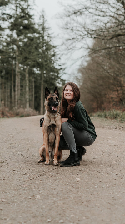 Female crouched down with her Belgian Malinois dog at Abbots Wood, Hailsham