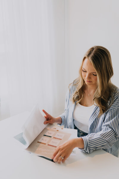Megan Evans flipping through financial papers at a white table