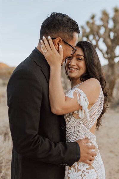 bride and groom embracing bride smiling