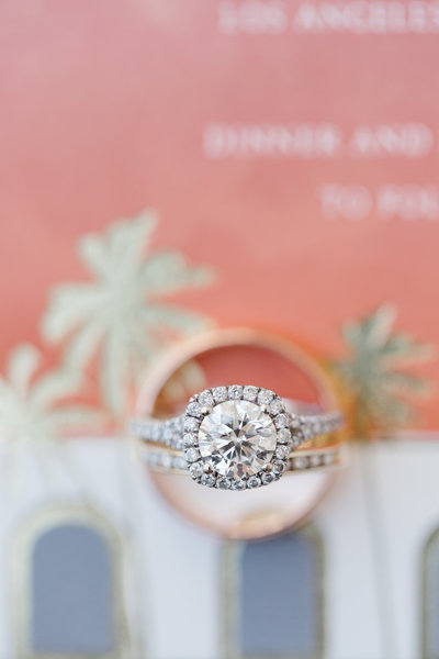 diamond engagement ring with Union Station LA wedding invitation in the background