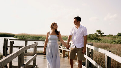 Couple walks along dock during engagement session