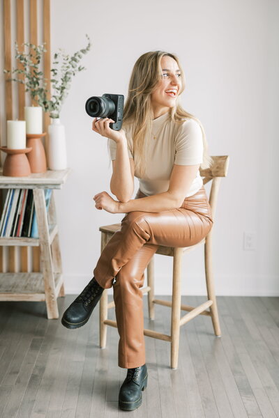 woman holding camera sitting down
