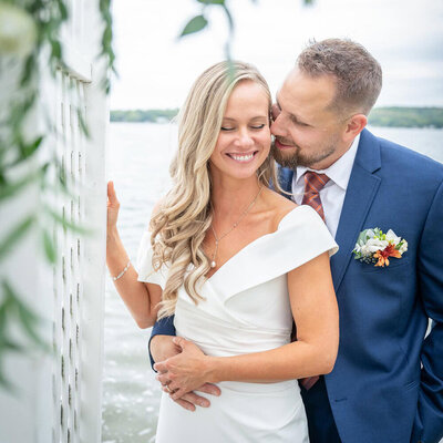grooms holds brides face amongst flowers