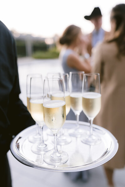 Wedding reception table with orange floral centerpiece in front of outdoor fountains