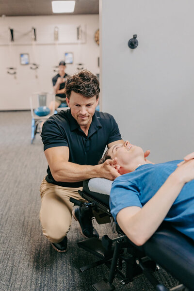 girl getting neck adjusted at chiropractor's office