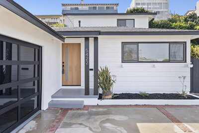 Black and white modern home exterior with wood front door and updated garage in Venice, California