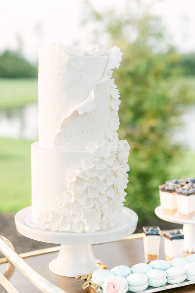 A stunning white wedding cake with delicate ruffle details, crafted by DFlavorCC for a luxury wedding in Savannah, GA. Captured by Amia Marcell editorial Photographer.