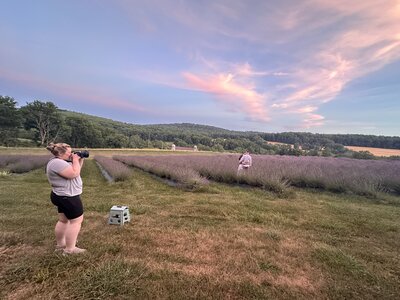 woman taking a photo of a couple in a lavender field in Pennsylvania