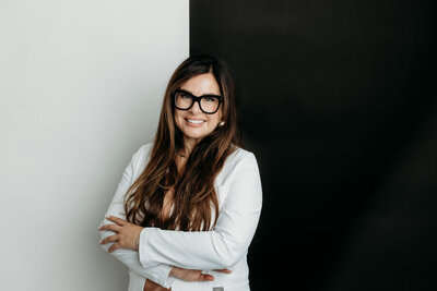 brunette female nurse and business owner wearing sweater and glasses