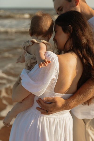 mom holding baby on beach in pei for lifestyle photos