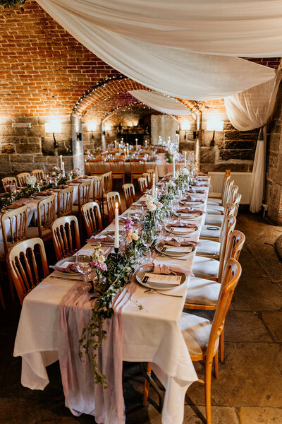 The Fort halls set up for a wedding. The room as chairs on each side with a round table at the end of the aisle and draping fro the ceiling