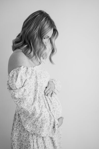 black and white photo of mom looking down at baby during studio newborn session