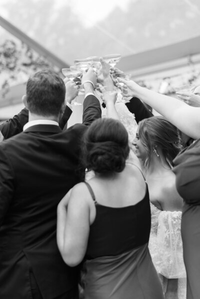 black and white image of guests cheers on dancefloor