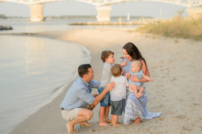 family of five playing on the beach at golden hour