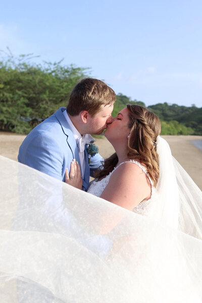 Bride and Groom kissing on the beach at Dreams Las Mareas 