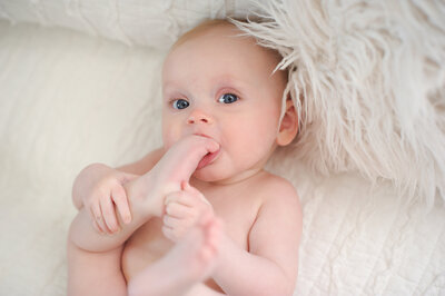 Baby chewing on toes at photo studio in Boise.