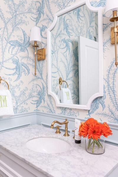 Bold patterned bathroom design with gold mirror