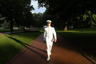 Sailor struts on Stribling walk for senior photos by Kelly Eskelsen at Naval Academy in Annapolis, Maryland