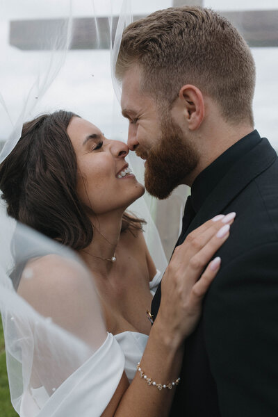 \Close-up of bride and groom leaning in for a kiss during intimate elopement, romantic detail shot capturing soft, candid moments for couples planning a small wedding