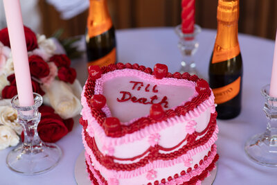 An Austin-based wedding photographer captures a romantic valentine's day cake with candles and a bottle of champagne.