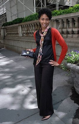 Standing near Bryant Park in New York City, I pose in chic corporate wear during my time as an accountant, captured for a feature by Essence Magazine, reflecting an early chapter in my professional journey.