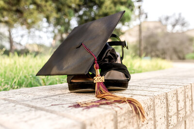 Graduation detail shot of black heels with cap and tassel resting on them