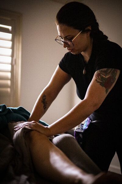 Lauren G massaging a clients knee on the massage table