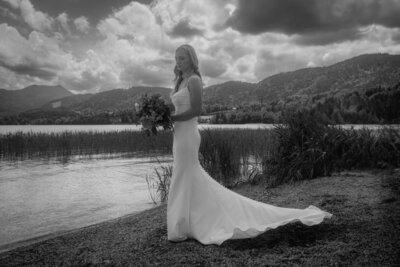 Black and white bridal portrait at a beautiful lake and a cloudy sky.
