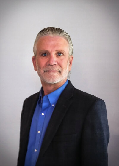 Man in a blue shirt and black suit